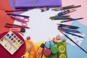 A vibrant selection of school supplies on a desk, including paints and stationery, ideal for creative projects.