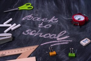 An arrangement of school supplies with 'back to school' written on a chalkboard.